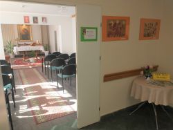 zdjęcie pomieszczenia przeznaczonego do modlitwy z ołtarzem i rzędami krzeseł